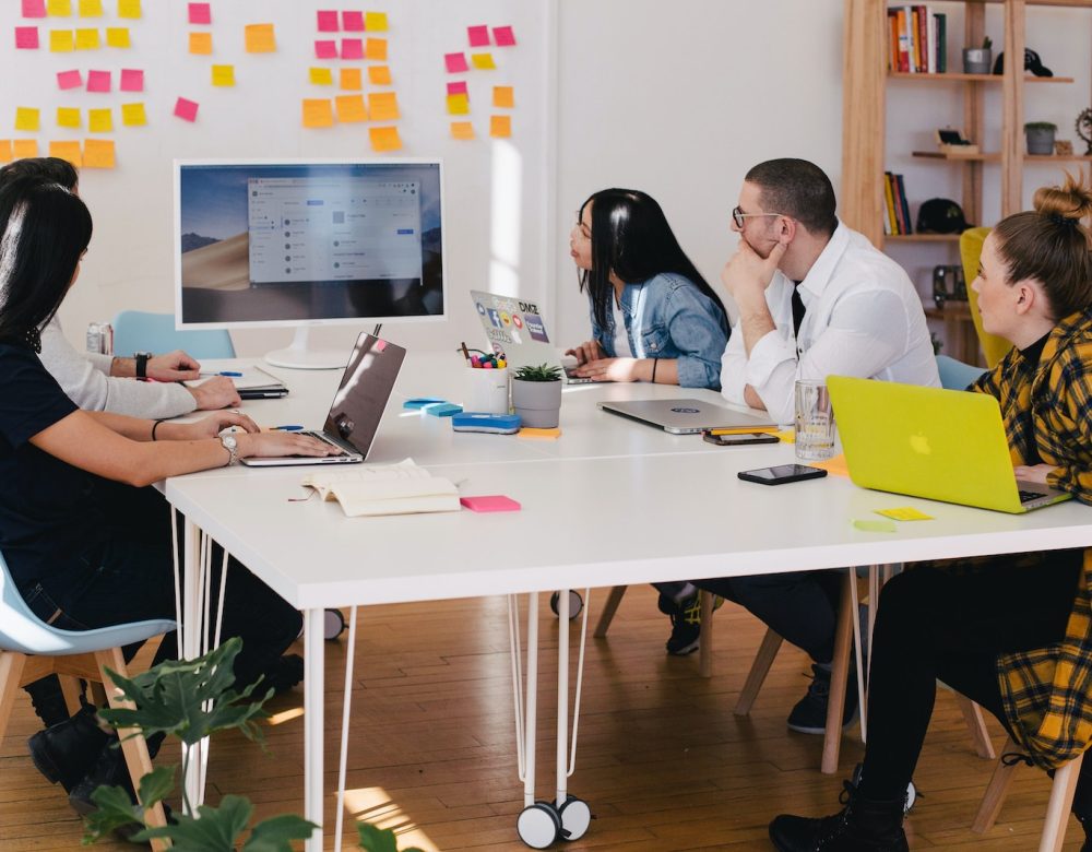 five person by table watching turned on white iMac